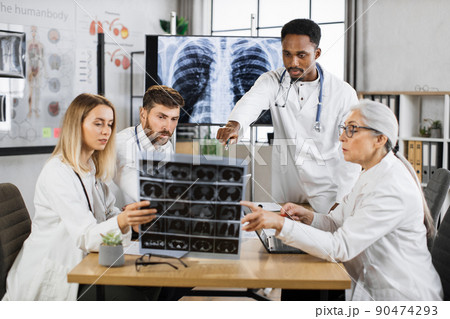 Team of medical workers analysing x ray results on meeting 90474293