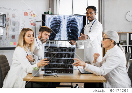 International doctors examining xray scan of lungs and brain 90474295