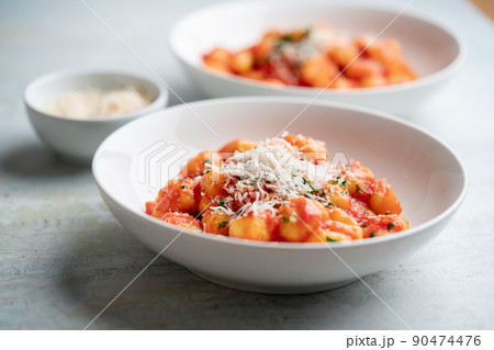 Gnocchi with tomato sauce and parmigiano on a plate 90474476
