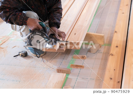 木造住宅の現場で電動ノコギリと曲尺で木材の加工をする大工 木造住宅の現場で電動ノコギリと曲尺で木材の加工をする大工 90475929
