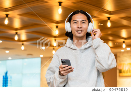 スマホを持つヘッドフォンの男性 スマホを持つヘッドフォンの男性 90476819
