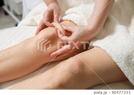 Close up of knee massage procedure in spa salon. Close up of knee massage procedure in spa salon. 90477333