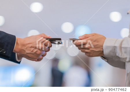 名刺交換をするエンジニアとビジネスマン　顔無し 90477462