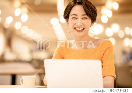 カフェでノートパソコンを使うミドル女性 90478485