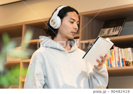 本を読むヘッドフォンの男性 90482419