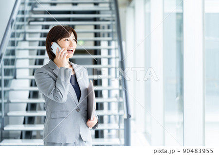 スマホを持つ女性社員 女性ビジネスマン スマホを持つ女性社員 女性ビジネスマン 90483955