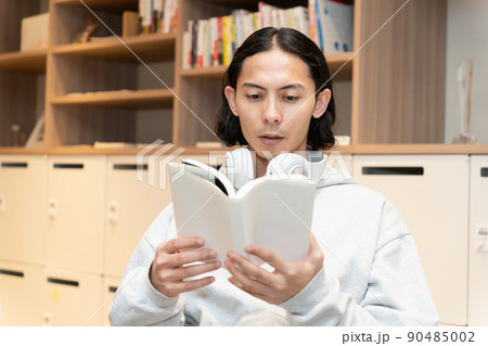本を読むヘッドフォンの男性 本を読むヘッドフォンの男性 90485002