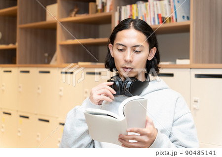 本を読むヘッドフォンの男性 90485141