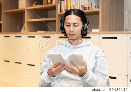 本を読むヘッドフォンの男性 90485152