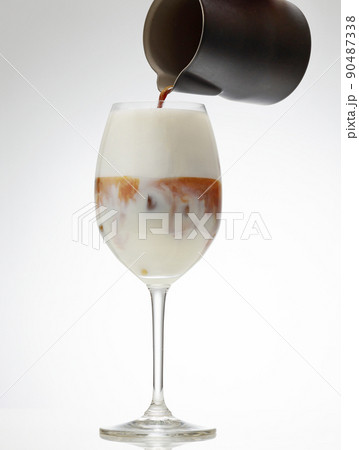coffee espresso pouring into glass of iced milk coffee espresso pouring into glass of iced milk 90487338
