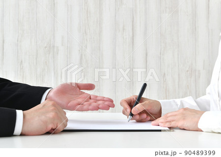 契約書にサインする人物とビジネスマンの手元 契約書にサインする人物とビジネスマンの手元 90489399