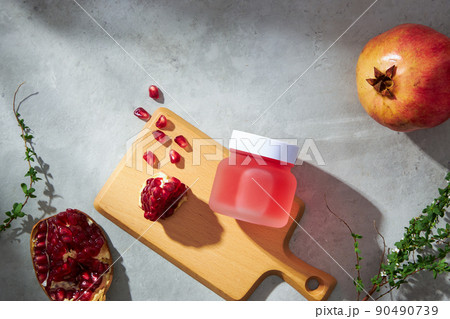 Fresh Pomegranates and pomegranate extract on a chopping board decoration on grey concrete background , for food advertising , top view , green leaf 90490739