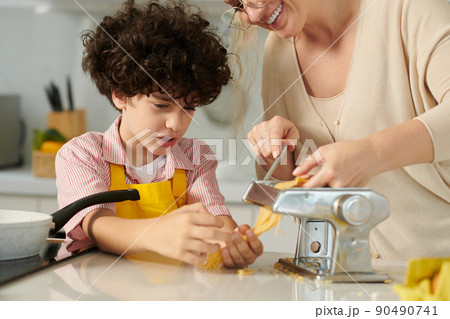 Boy Helping Mother with Making Pasta 90490741