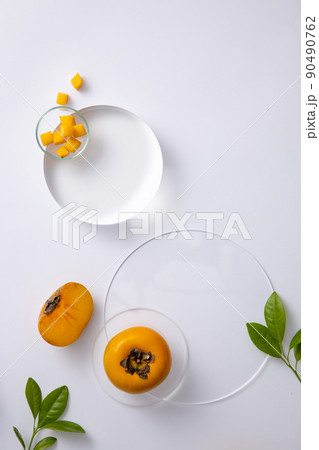 Topview of persimmon and seeds in the petri dish with transparent podium on white background. Research and develop cosmetics in laboratory for advertising Topview of persimmon and seeds in the petri dish with transparent podium on white background. Research and develop cosmetics in laboratory for advertising 90490762