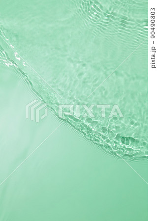Transparent light green colored clear water surface texture with ripples, splashes and bubbles. Abstract nature light green background Water waves in sunlight with blank space for cosmetic advertising 90490803