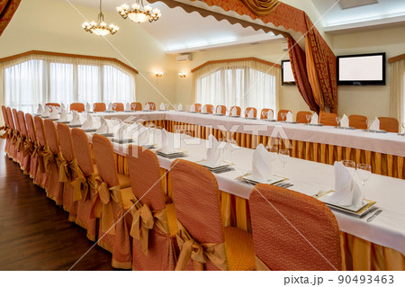 Served tables arranged in banquet hall prepared for festive celebration Served tables arranged in banquet hall prepared for festive celebration 90493463