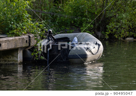 inflatable Rubber fishing boat on a tranquil lake shore. 90495047