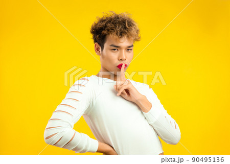 Portrait of a handsome gay man with red lip stick and white shirt. Transgender male LGBTQ+ concept 90495136