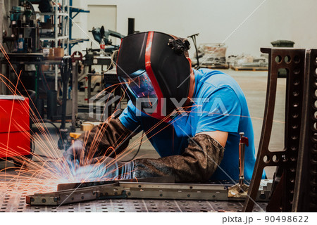 Professional Heavy Industry Welder Working Inside factory, Wears Helmet and Starts Welding. Selective Focus 90498622