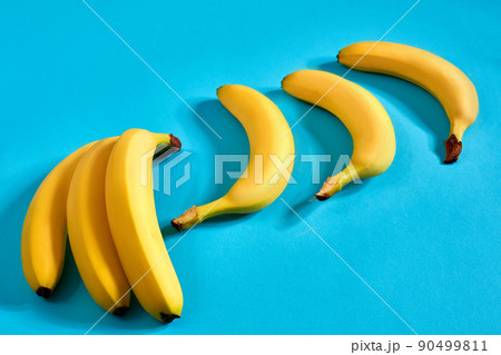 Yellow ripe bananas on blue background with space for text or design. Top view 90499811