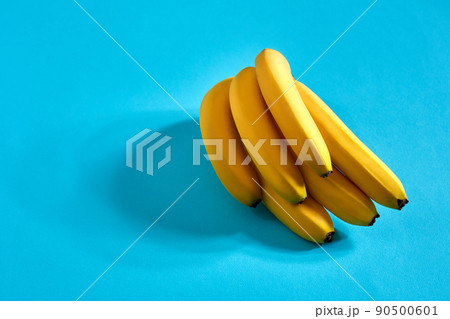 Yellow ripe bananas on blue background with space for text or design. Top view 90500601