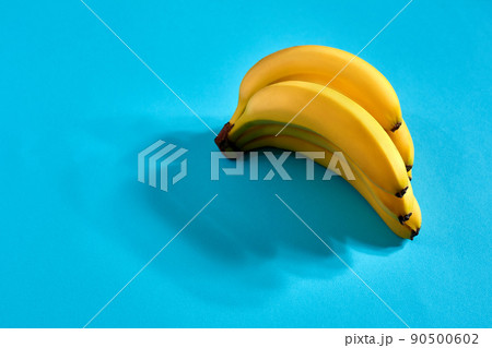 Yellow ripe bananas on blue background with space for text or design. Top view Yellow ripe bananas on blue background with space for text or design. Top view 90500602