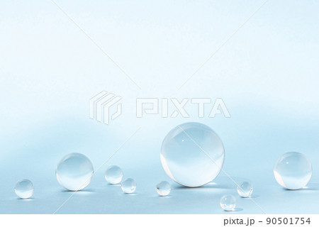 Blue background with transparent glass balls. Minimal concept and soft sunlight. 90501754