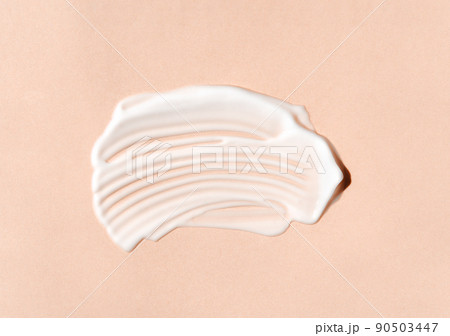Texture of white cream on beige background. Smear of moisturizer closeup. Lotion swatch. Beauty, skin care product smear smudge drop. SPF sunscreen cream sample 90503447