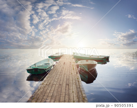 Small wooden dock and boats at the lake against sky clouds background 90505391