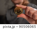 Close-up hand of woman investor showing, holding gold Bitcoin Cryptocurrency. 90506065