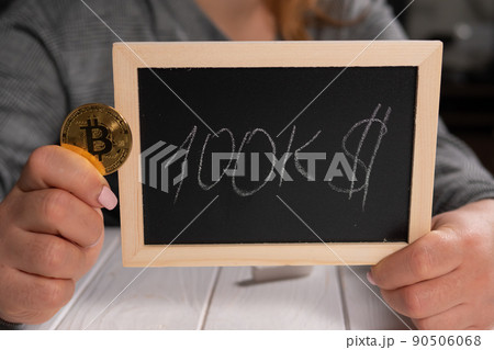 A woman holding a board with the inscription 100 thousand dollars and a bitcoin. 90506068