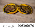 Close-up of a completely rotten cut mango on a wooden background 90506070