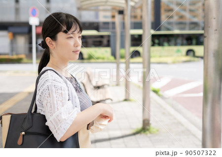 バス停でバスを待つ笑顔の女性 90507322