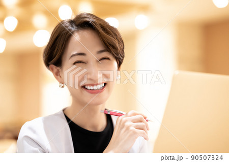 ノートパソコンを使うオフィスカジュアルのミドル女性 90507324
