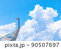 夏空に浮かぶ入道雲と恐竜のオブジェ 90507697