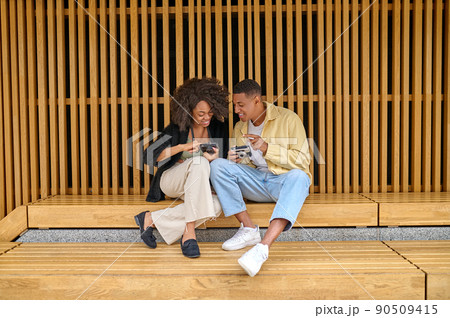 Guy and girl sitting and staring at camera 90509415