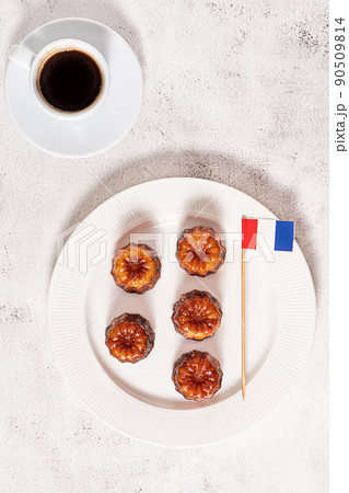 A cup of coffee and French dessert canele on grey background 90509814