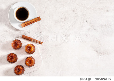 A cup of coffee and French dessert canele on grey background 90509815