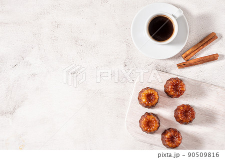 A cup of coffee and French dessert canele on grey background 90509816