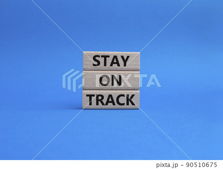 Stay on track symbol. Wooden blocks with words 'Stay on track'. Beautiful blue background. Business and 'Stay on track' concept. Copy space. 90510675