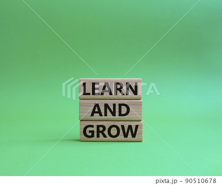 Learn and grow symbol. Concept words 'Learn and grow' on wooden blocks. Beautiful green background. Business and Learn and grow concept. Copy space. 90510678