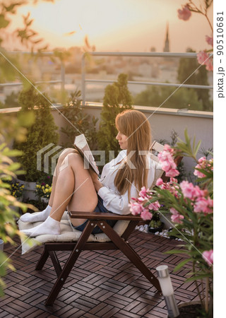 Woman Reading Book on Rooftop Terrace 90510681