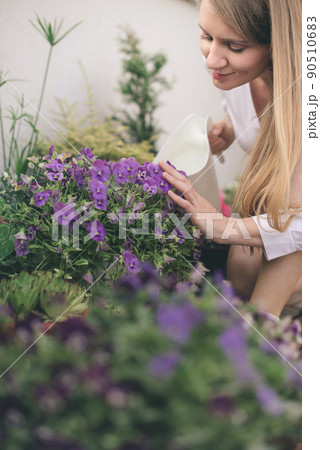 Woman Watering Flowers on Rooftop Garden 90510683