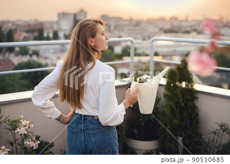 Woman Watering Can on Rooftop Garden 90510685