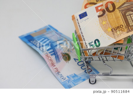 Toy grocery cart and banknotes, shopping for goods, exchange rate volatility. 90511684