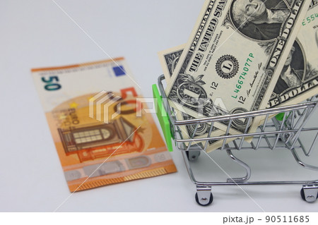Toy grocery cart and banknotes, shopping for goods, exchange rate volatility. Toy grocery cart and banknotes, shopping for goods, exchange rate volatility. 90511685