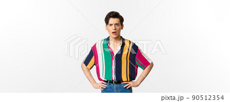 Image of confused and upset young man staring at camera, standing disappointed over white background Image of confused and upset young man staring at camera, standing disappointed over white background 90512354