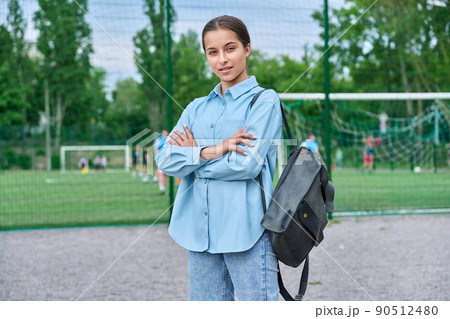 Portrait of teenage female student looking at camera, school stadium background 90512480