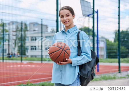 Portrait of teenage student girl with backpack and basketball ball 90512482