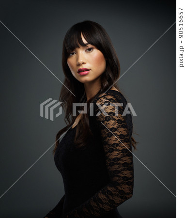 Confidence makes all the difference. Studio shot of a beautiful young woman posing against a dark background. 90516657